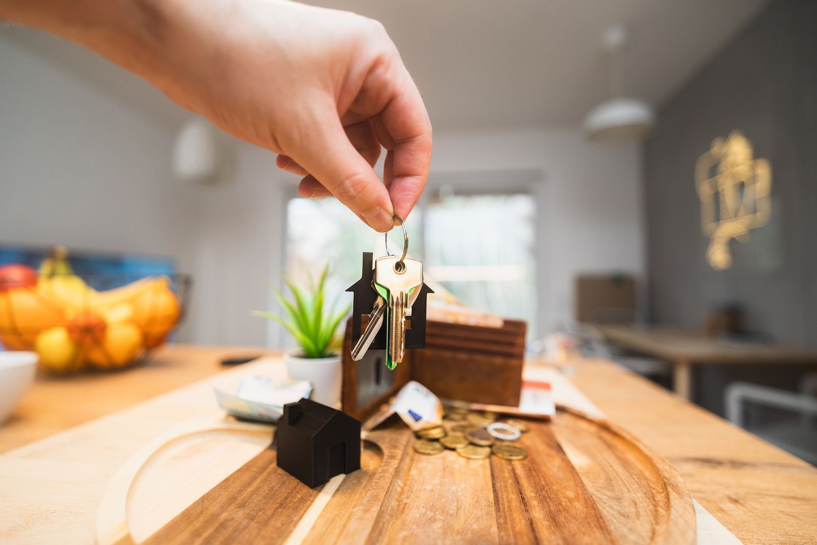 Mains tenant des clés de logement au-dessus d'un salon moderne, symbole d'un premier emménagement