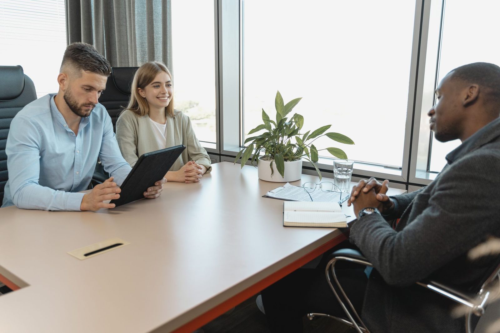 Two recruiters facing a candidate during a job interview around a meeting table