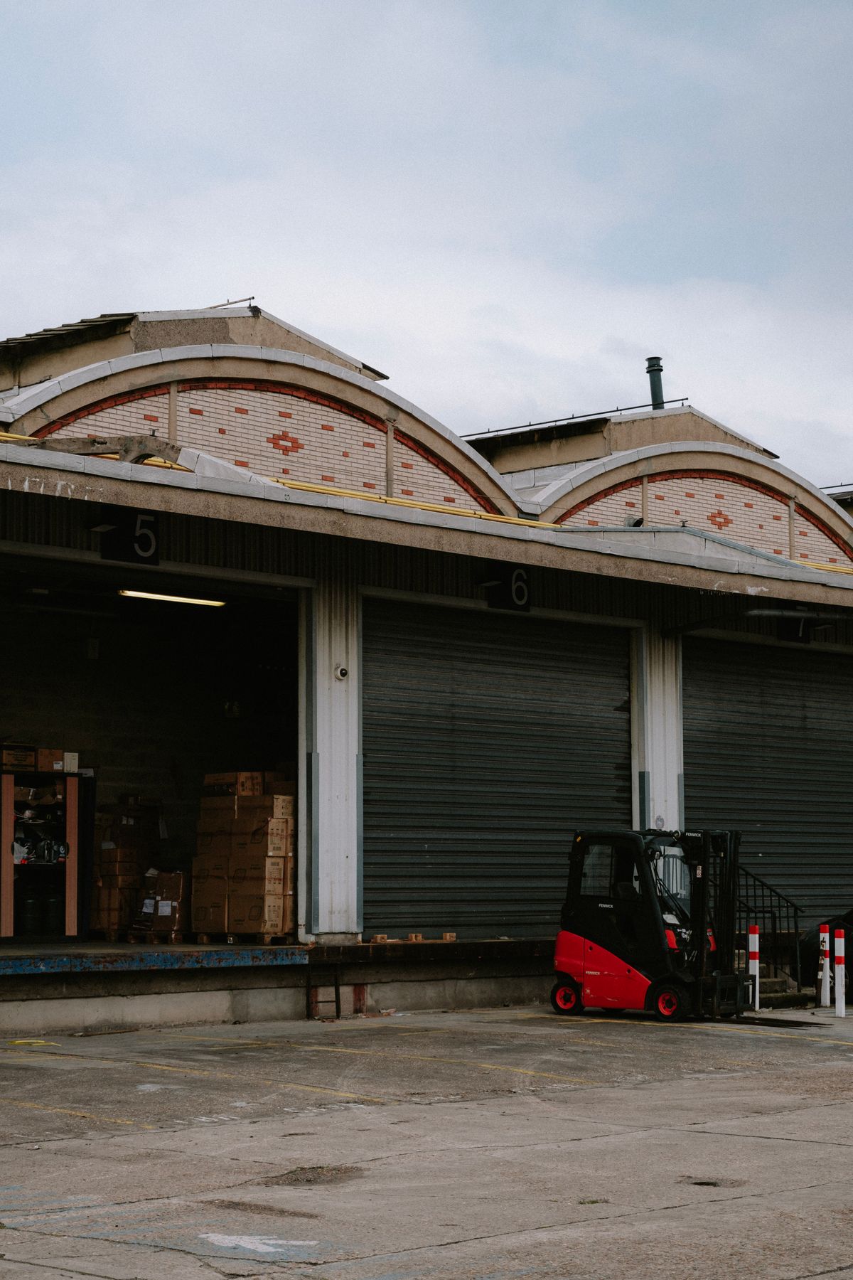 Employee standing in front of a forklift in a logistics warehouse, illustrating logistics trades through apprenticeship
