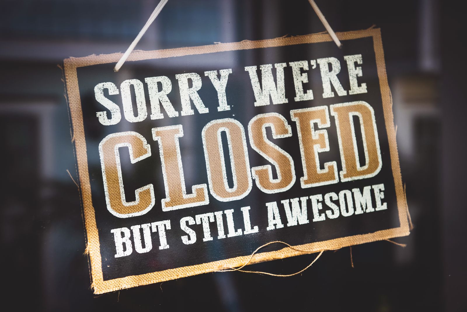 A “Sorry we're closed” sign hanging on a company door handle, illustrating the annual summer closure of a business employing an apprentice