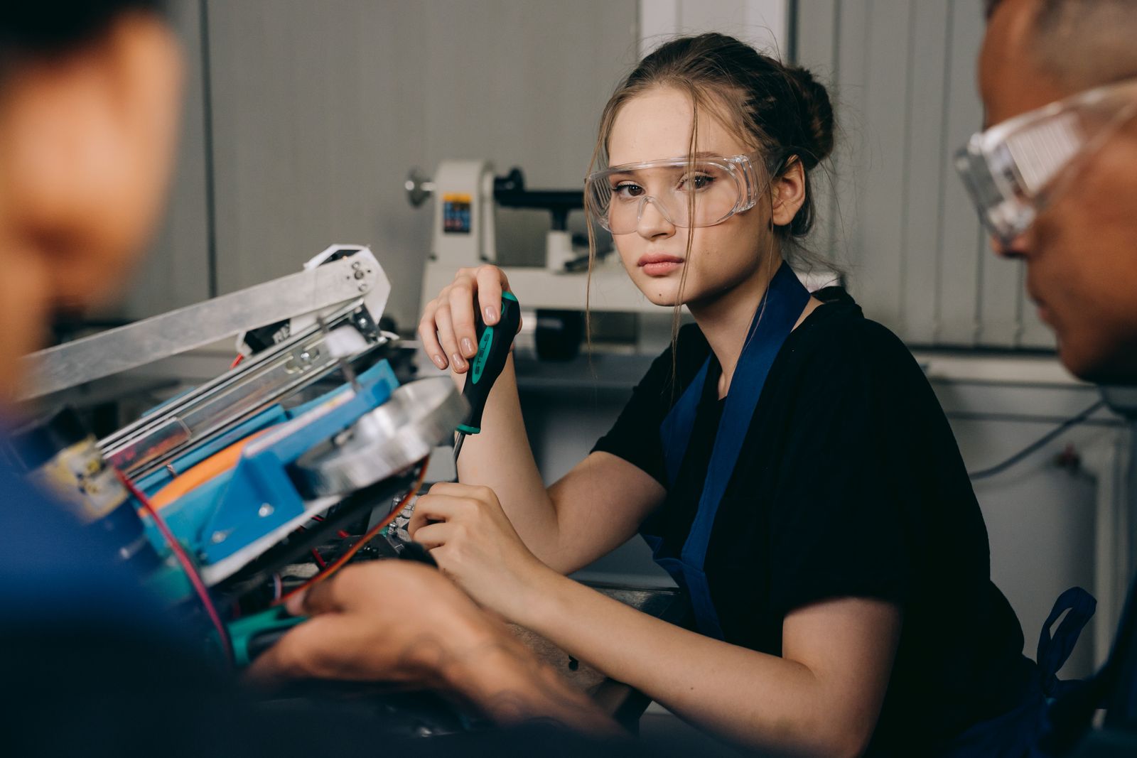 Jeune femme ingénieure en tenue de travail avec casque dans un atelier industriel, illustrant un parcours d'apprentissage réussi après 30 ans