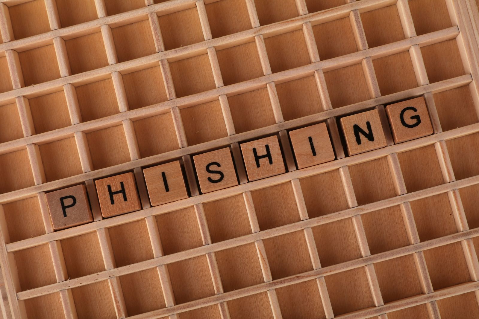 Buchstaben aus Holz, die das Wort phishing bilden und den Betrug an Ausbildungssuchenden veranschaulichen