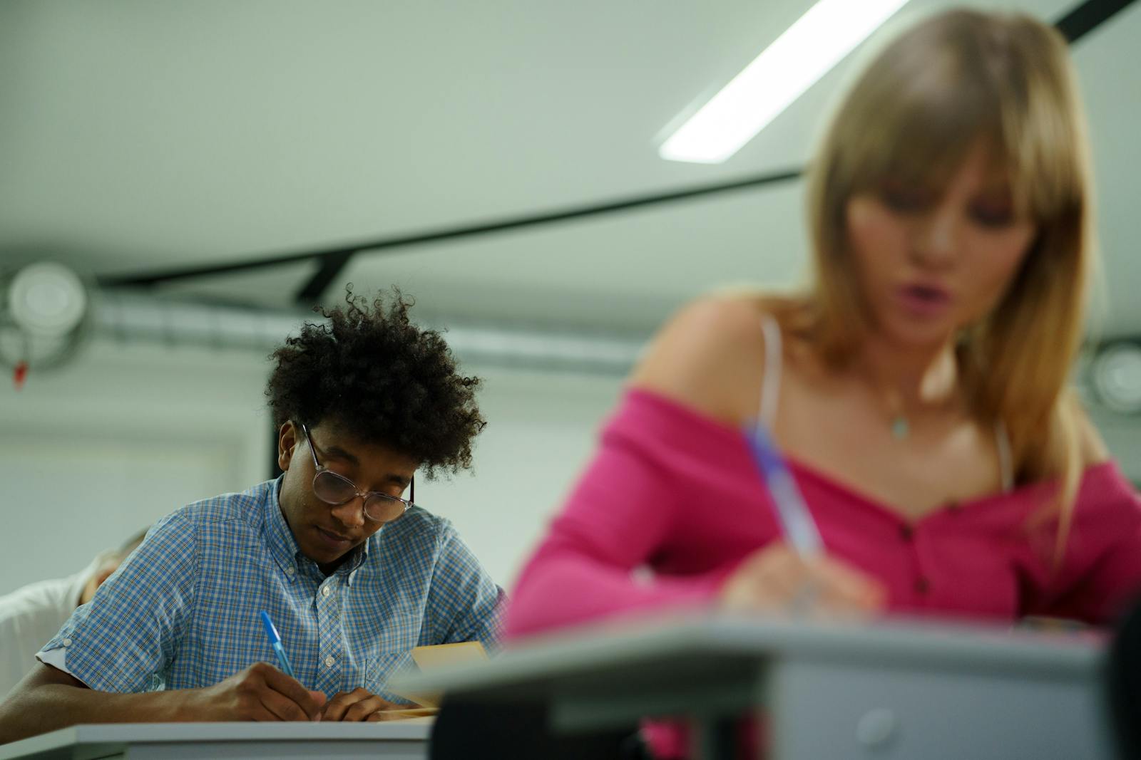 Dwoje licealistów skupionych podczas pisania egzaminu pisemnego baccalauréat
