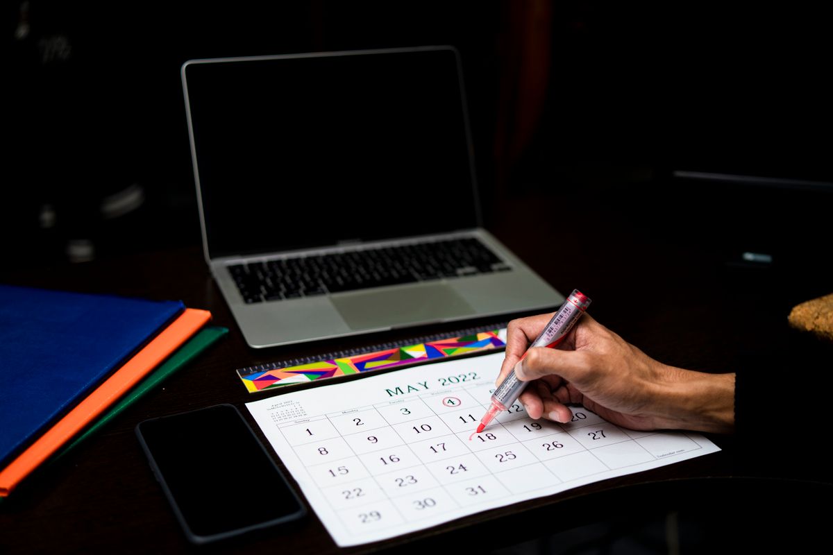 Persona che segna una data su un calendario per prenotare le ferie da apprendista