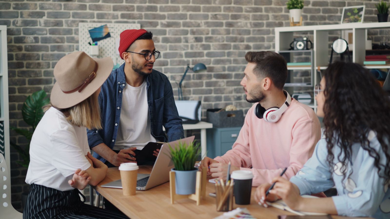 Giovane team che discute un progetto in un ufficio moderno, simbolo delle assunzioni di apprendisti in azienda