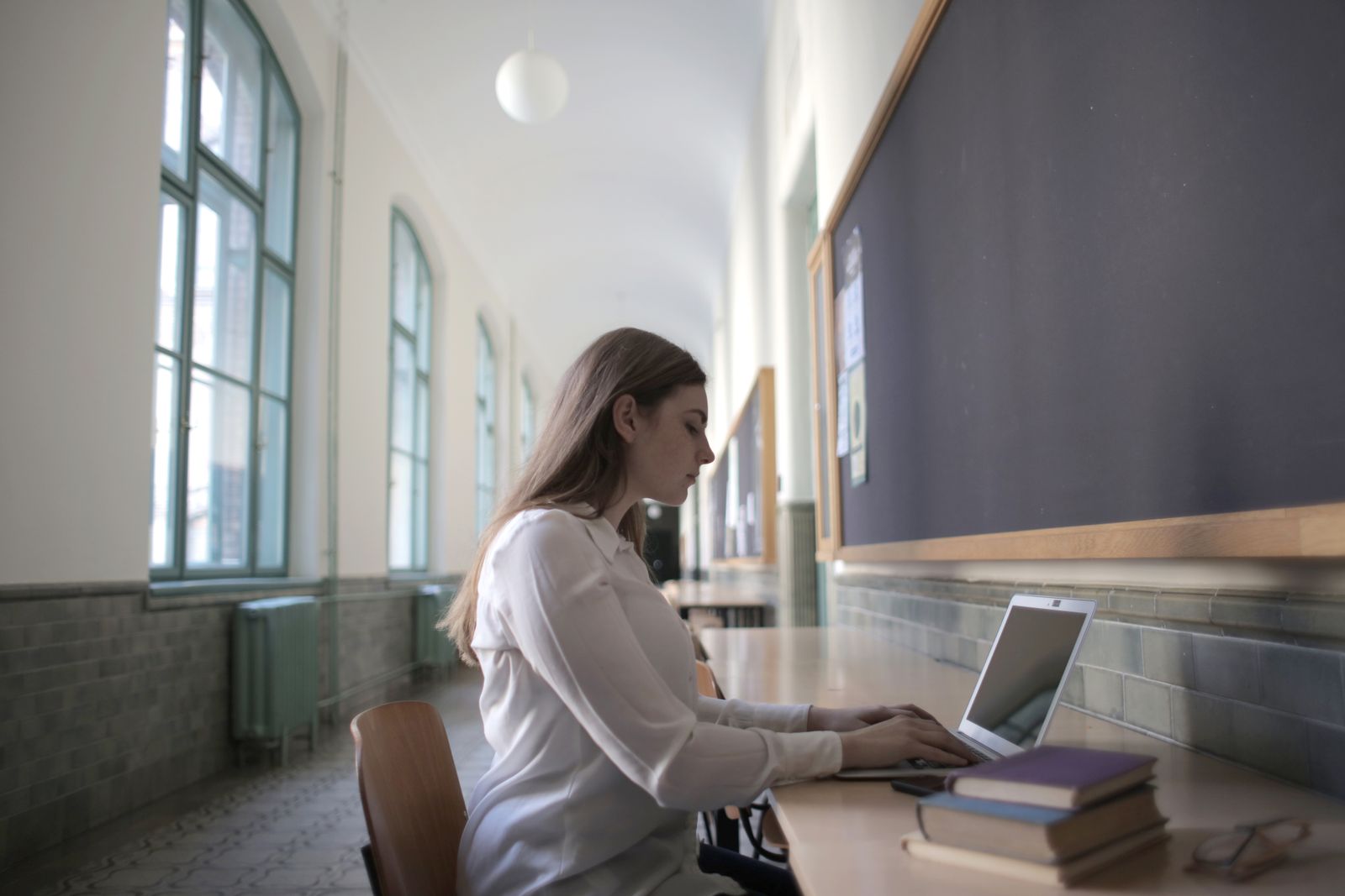 Studentessa concentrata che consulta le sue proposte di ammissione Mon Master sul portatile