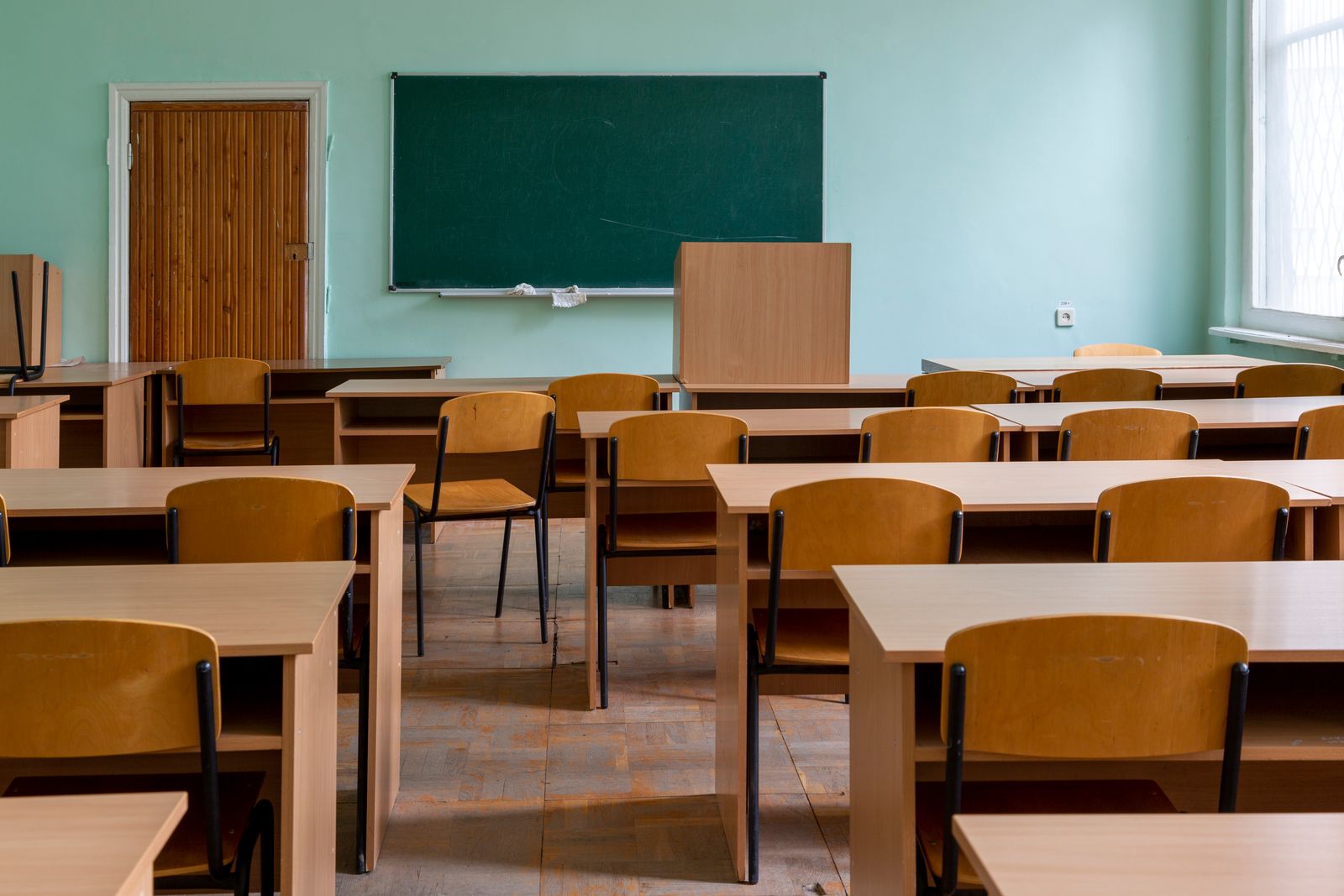 Empty classroom with desks and a green chalkboard, illustrating the threat facing CFA