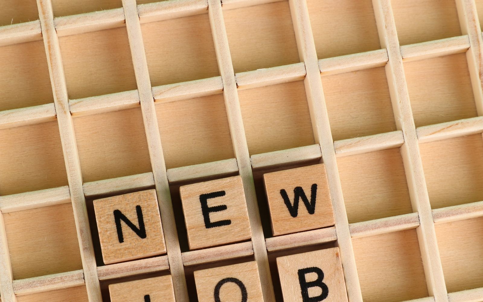 Lettere di legno che compongono la parola «New Job», simbolo di una riconversione professionale